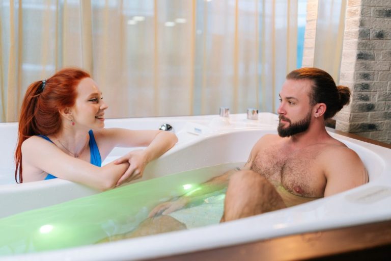 Couple vérifiant l’espace et le jacuzzi privatif d’une love room à Paris avant la réservation